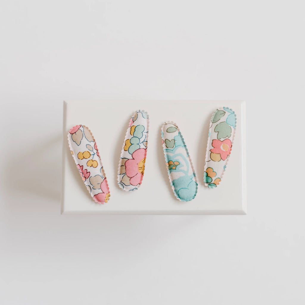 Three floral-patterned hair clips on a white background