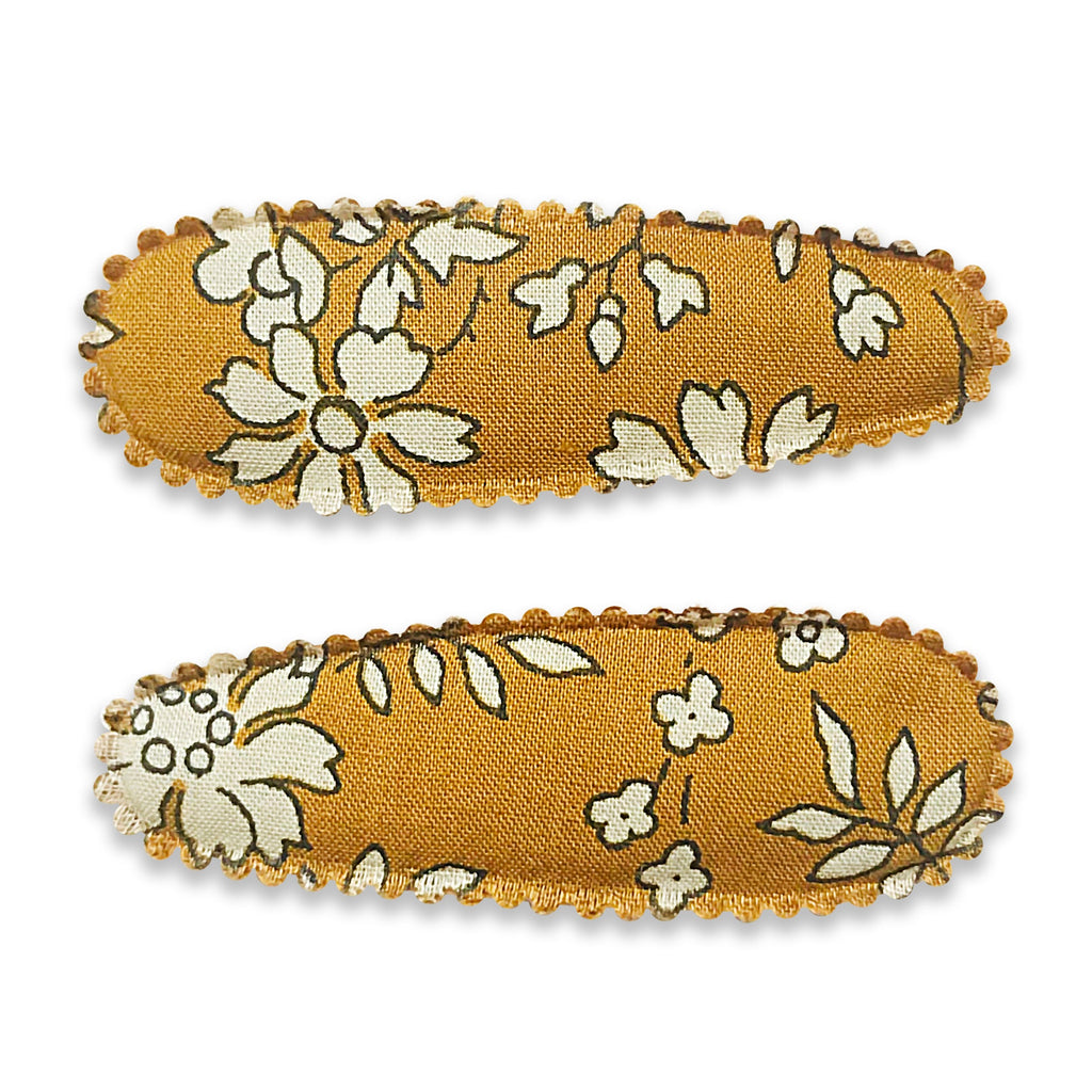Two fabric-covered snap hair clips with a floral pattern on a yellow background.