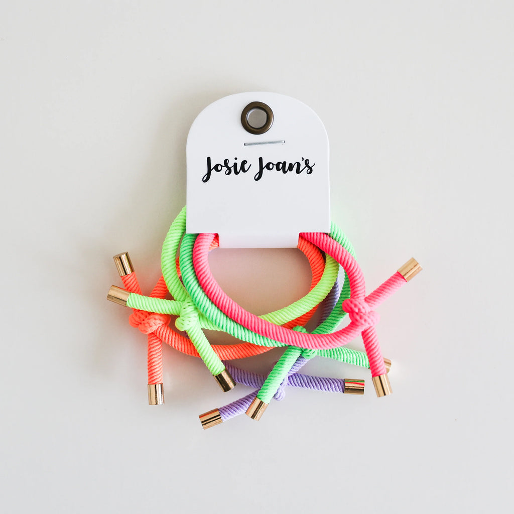 Josie Joan's Neon Nora Hair Ties set displayed on branded card, featuring neon green, pink, orange, and purple elastics with gold metal tips.
