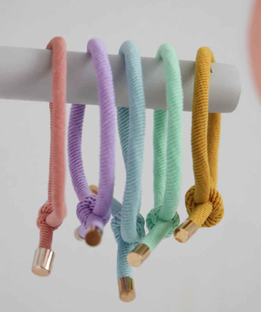 Five colorful hair ties on a white background