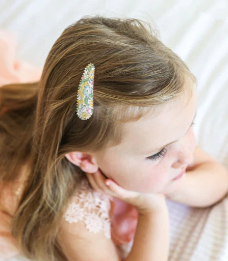 Child with decorative hair clip on a soft background