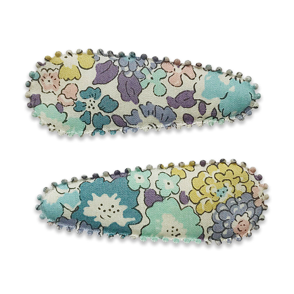 Two fabric-covered snap hair clips with a floral pattern placed on a white background.
