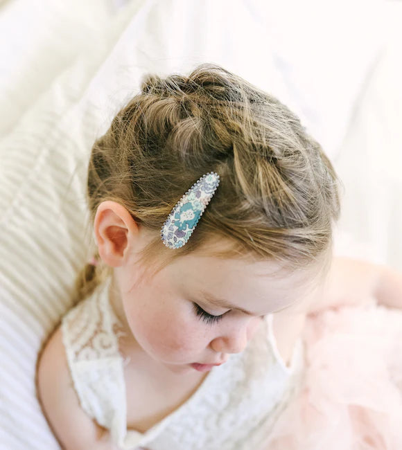 Child with decorative hair clip on a soft white background