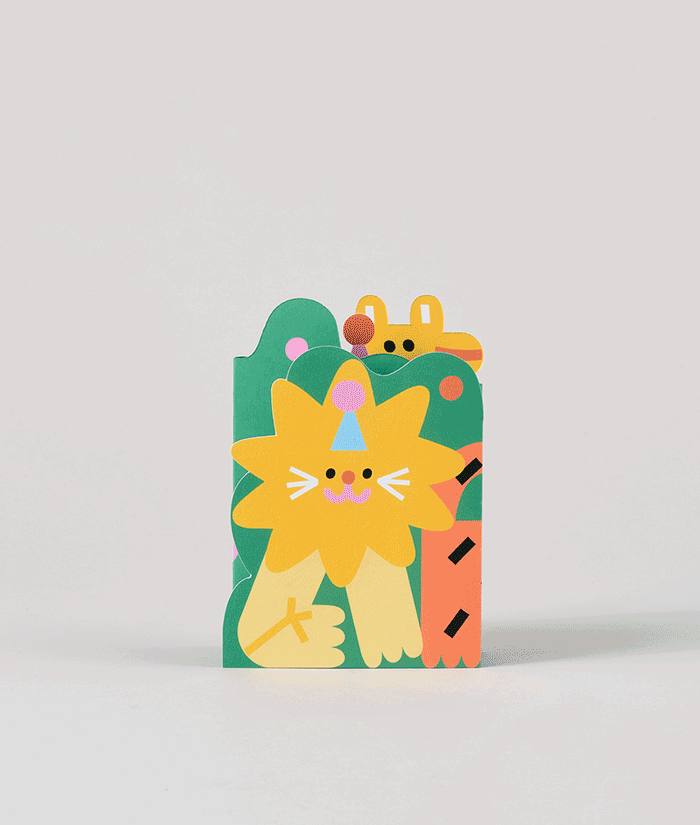 Side angle of jungle-themed fold-out birthday card with cut-out shapes of animals and tropical plants, partially folded to reveal dimensional layers.