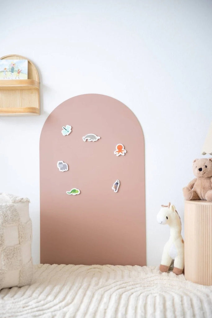 A Clay coloured MagPlay magnetic wall decal in a child’s room, decorated with cute magnetic animal stickers, placed next to plush toys and soft neutral decor.