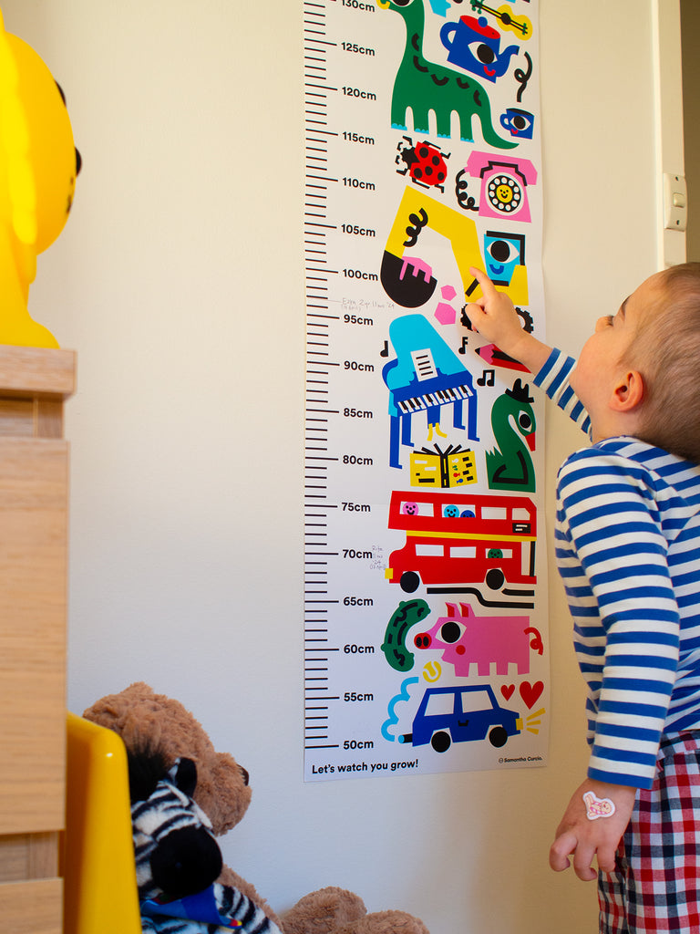 Vibrant height chart featuring playful illustrations of dogs, elephants, planes, and dinosaurs, designed by Melbourne illustrator Samantha Curcio. Made with durable, high-quality material, perfect for tracking growth in bedrooms or playrooms.