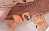 Flamingo-shaped teething toys on a textured surface