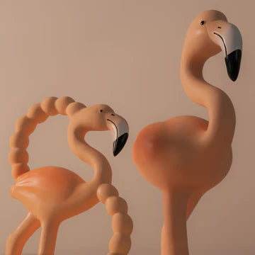 Two pink flamingo figurines on a beige background