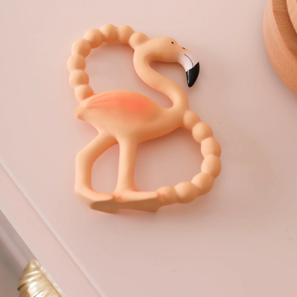 Flamingo-shaped teething ring on a light pink background