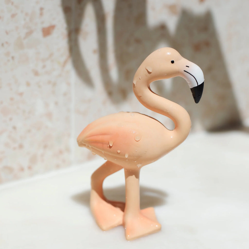 Flamingo figurine on a textured surface with a blurred background