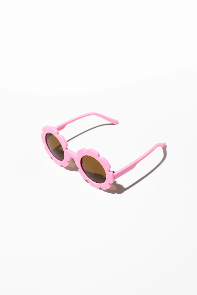 A pair of berry pink kids sunglasses with a daisy pattern, placed on a white surface.