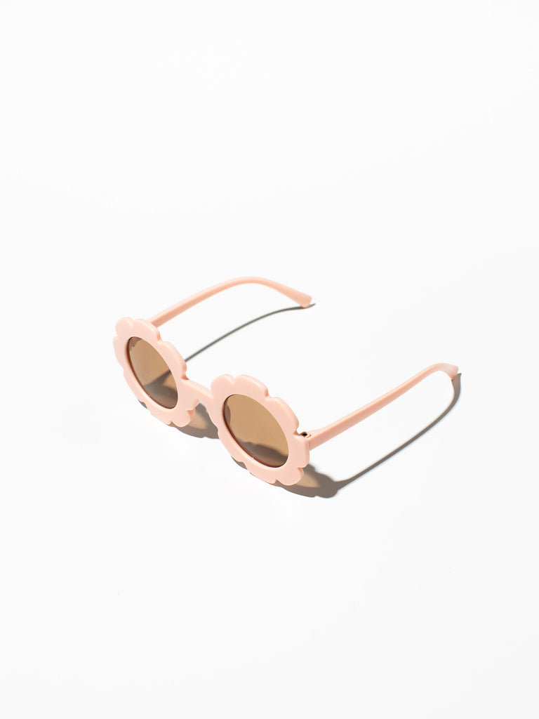 A pair of peachy pink kids sunglasses with a silicone case and microfiber cleaning cloth.