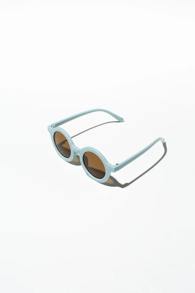 A pair of light blue kids sunglasses with a silicone case and microfiber cleaning cloth.