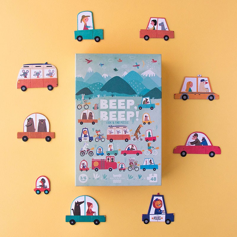Londji Beep Beep Puzzle box surrounded by colorful car-shaped pieces on a yellow background.