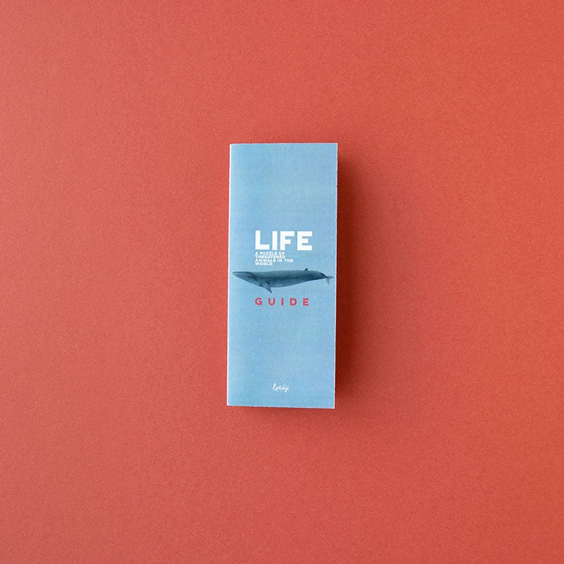 Close-up of the Londji Life Puzzle guide booklet with a blue cover and whale illustration.