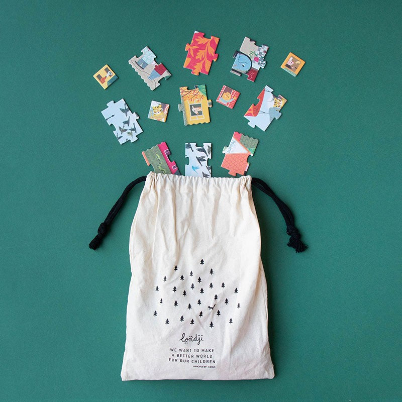 Londji Look Up puzzle pieces spilling from a cotton drawstring bag with eco-friendly design.