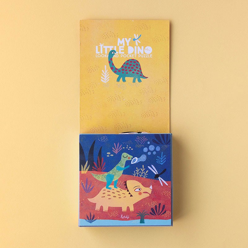Open box of Londji My Little Dino Look & Find Pocket Puzzle showing a cute illustration of a green dinosaur riding a yellow one on a red and blue background.
