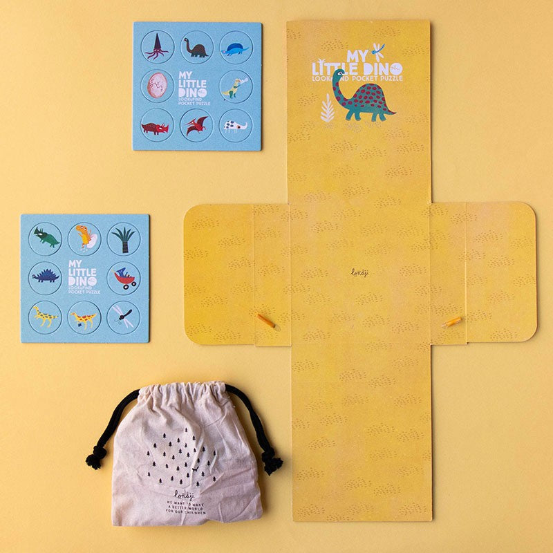 Contents of Londji My Little Dino Look & Find Pocket Puzzle laid out, including yellow box liner, illustrated cards, and small fabric pouch.