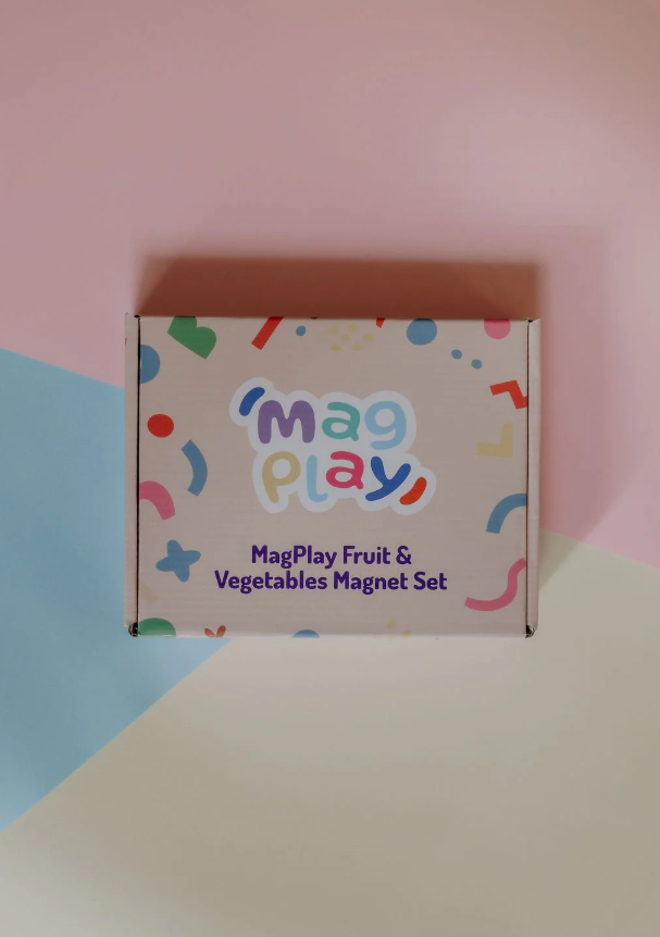 Alternate flat lay of the MagPlay Fruit & Vegetables Magnet Set box on a pastel geometric background, featuring updated packaging design.