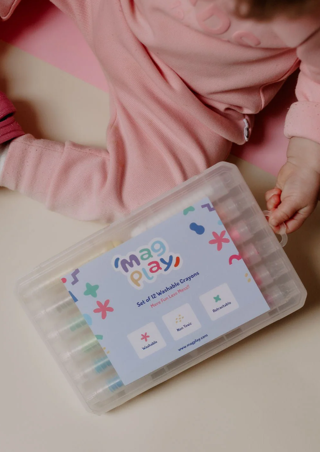 Crayon case with visible branding next to a toddler in pink clothing, ready to open or use the set.