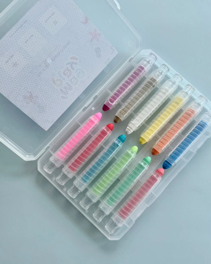 Open crayon case showing 12 colourful retractable gel crayons neatly arranged inside.