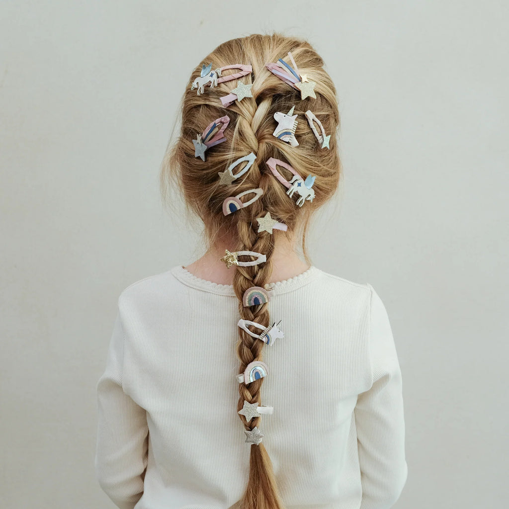 Braided hairstyle adorned with Mimi & Lula Celeste Mini Clips shaped like stars, rainbows, and unicorns.