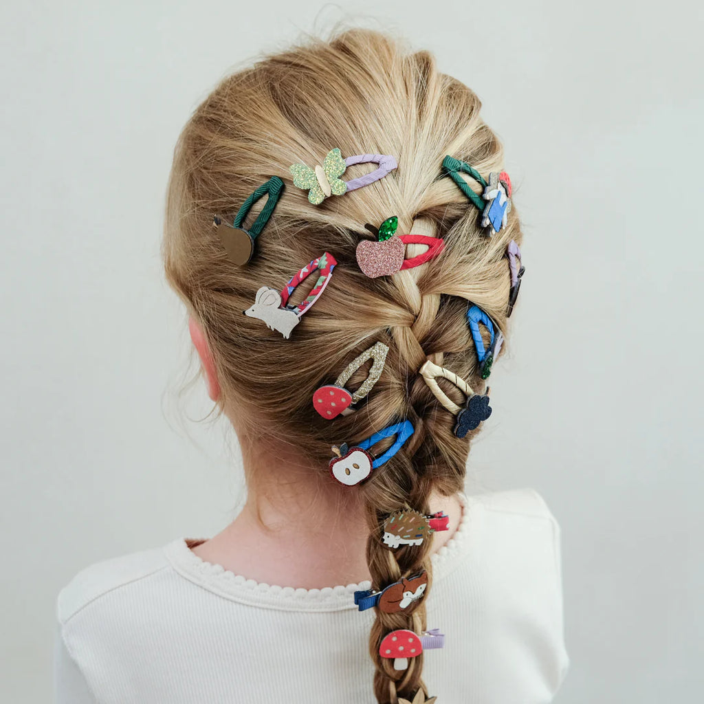 Girl wearing colorful Mimi & Lula Fruity Mini Clic Clacs in a braided hairstyle.