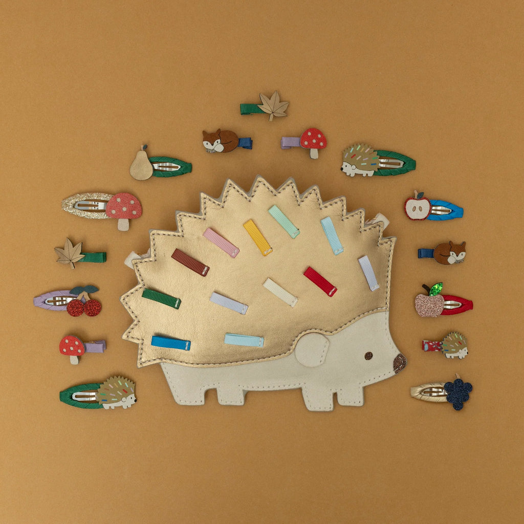 Flat lay of Mimi & Lula Fruity Mini Clic Clacs displayed with matching animal clips on hedgehog clip holder.