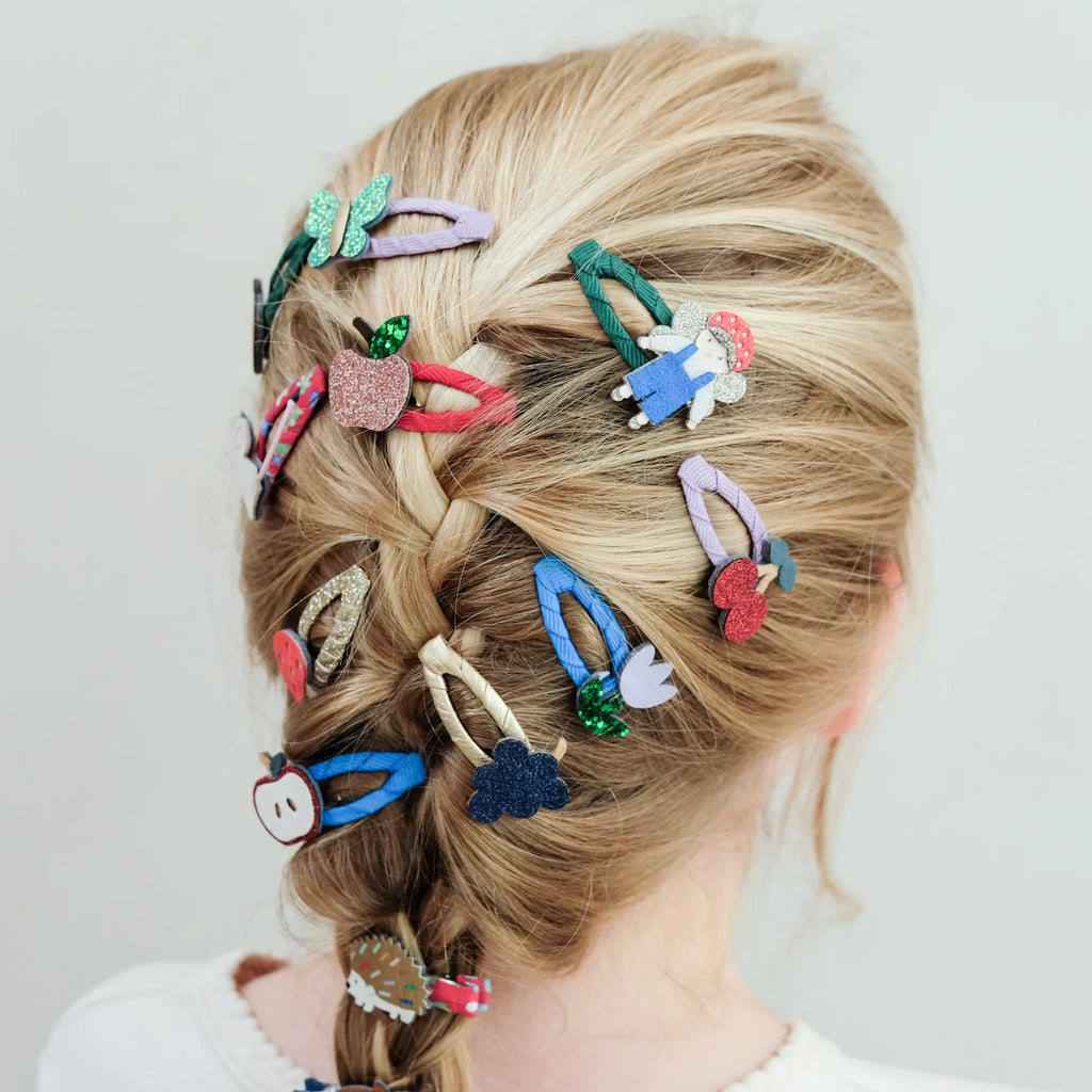 Blonde girl’s braided hair decorated with Mimi & Lula Fruity Mini Clic Clacs and animal clips.