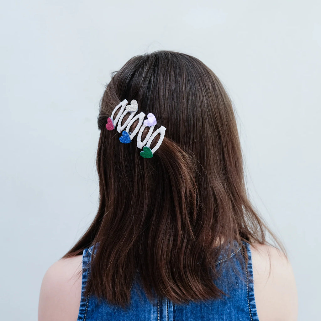 Girl wearing Mimi & Lula Jazzy Heart hair clips in colorful glitter design – stylish and fun kids hair accessory set.
