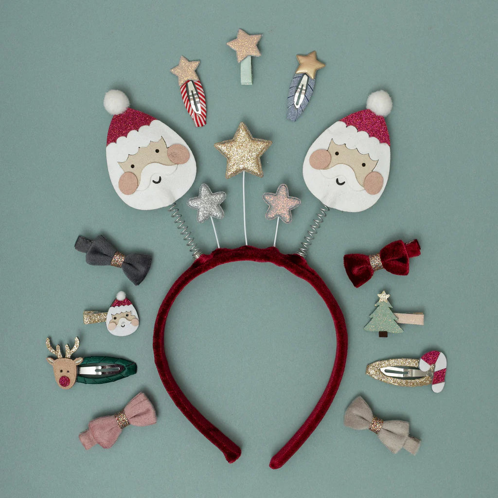 Christmas accessories flat lay featuring Mimi & Lula Santa & Rudolph Clic Clacs with bows and headbands.