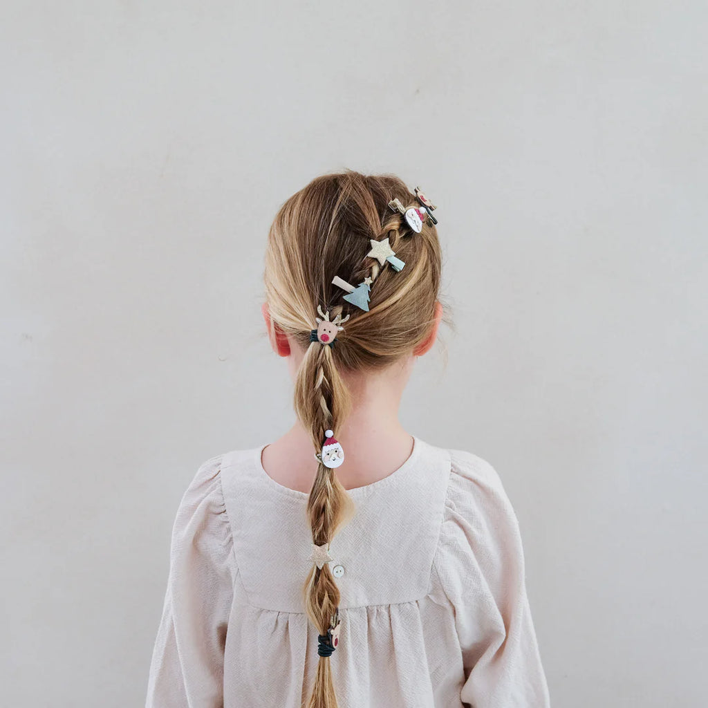 Back view of girl’s festive braid decorated with Mimi & Lula Santa & Rudolph clips.