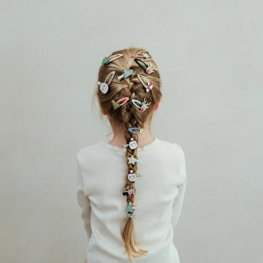 Girl with Christmas hairstyle covered in multiple Mimi & Lula Santa, reindeer, and tree hair clips.