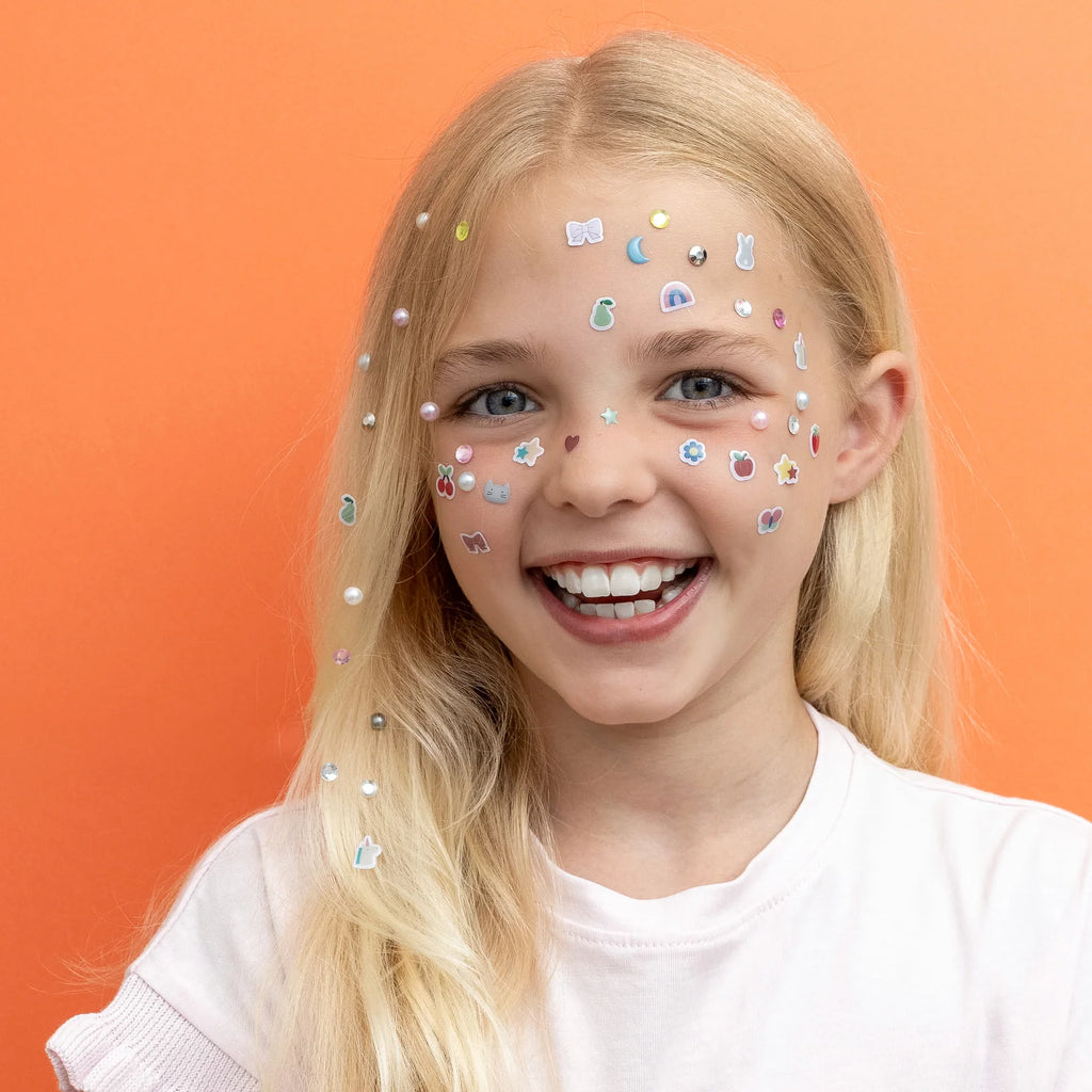 Girl wearing playful face stickers and pearls with Mimi & Lula earrings