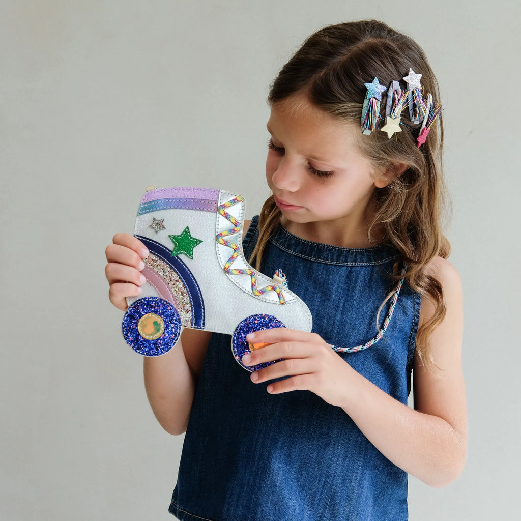 Child holding sparkly roller skate bag wearing Mimi & Lula Tinsel Star hair clips.