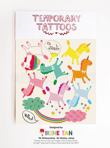 Colourful sheet of temporary tattoos featuring hand-drawn rainbow unicorns, stars, clouds, and rainbows by Missy Minzy. Each unicorn is uniquely coloured and playfully posed, set against a cream background with whimsical speech bubbles and decorative elements.