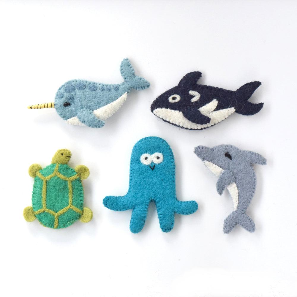 Set of five wool felt finger puppets featuring marine creatures—orca, narwhal, octopus, turtle, and dolphin displayed on white.