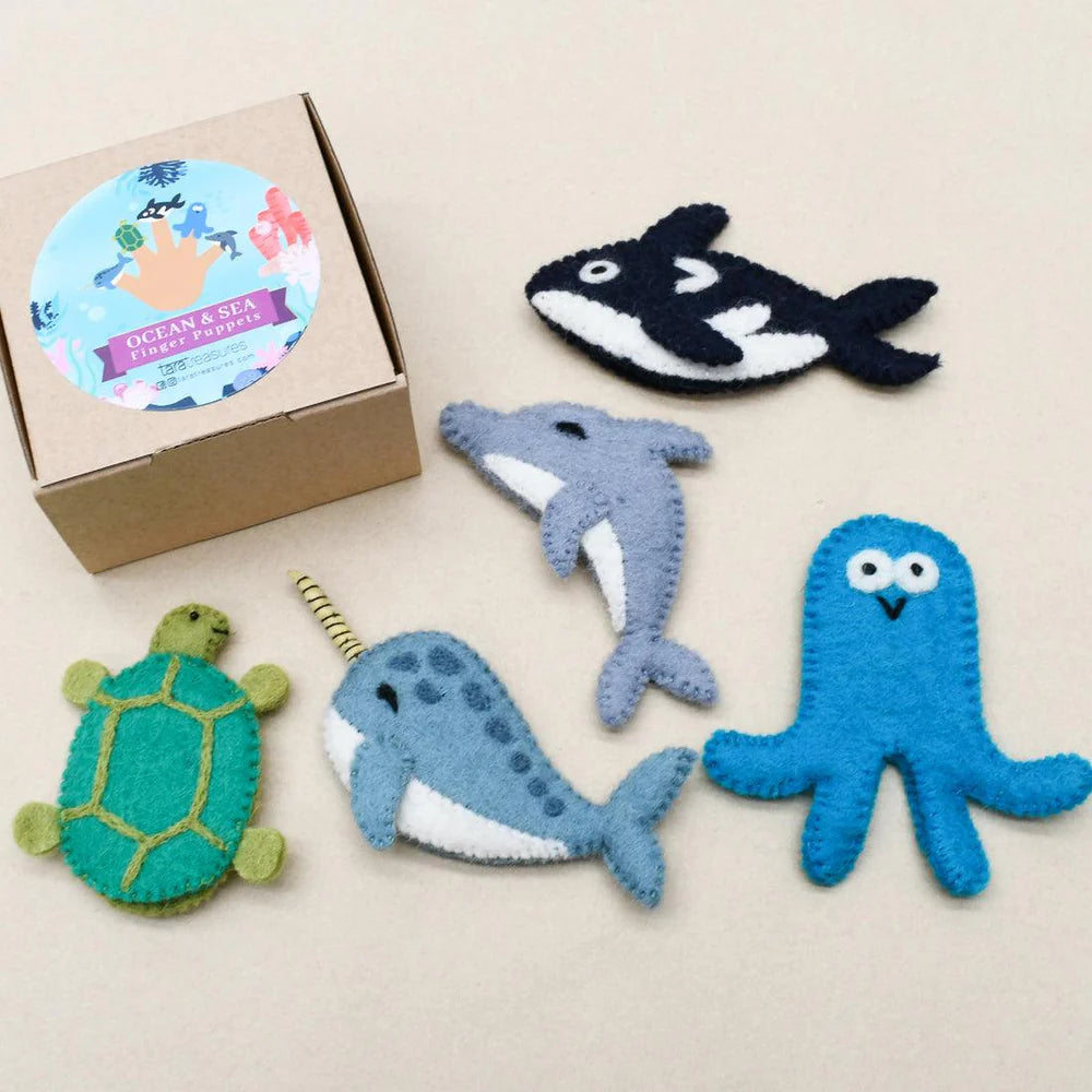 Flat lay of Tara Treasures ocean animal finger puppets next to a branded box—includes octopus, killer whale, turtle, and dolphin.