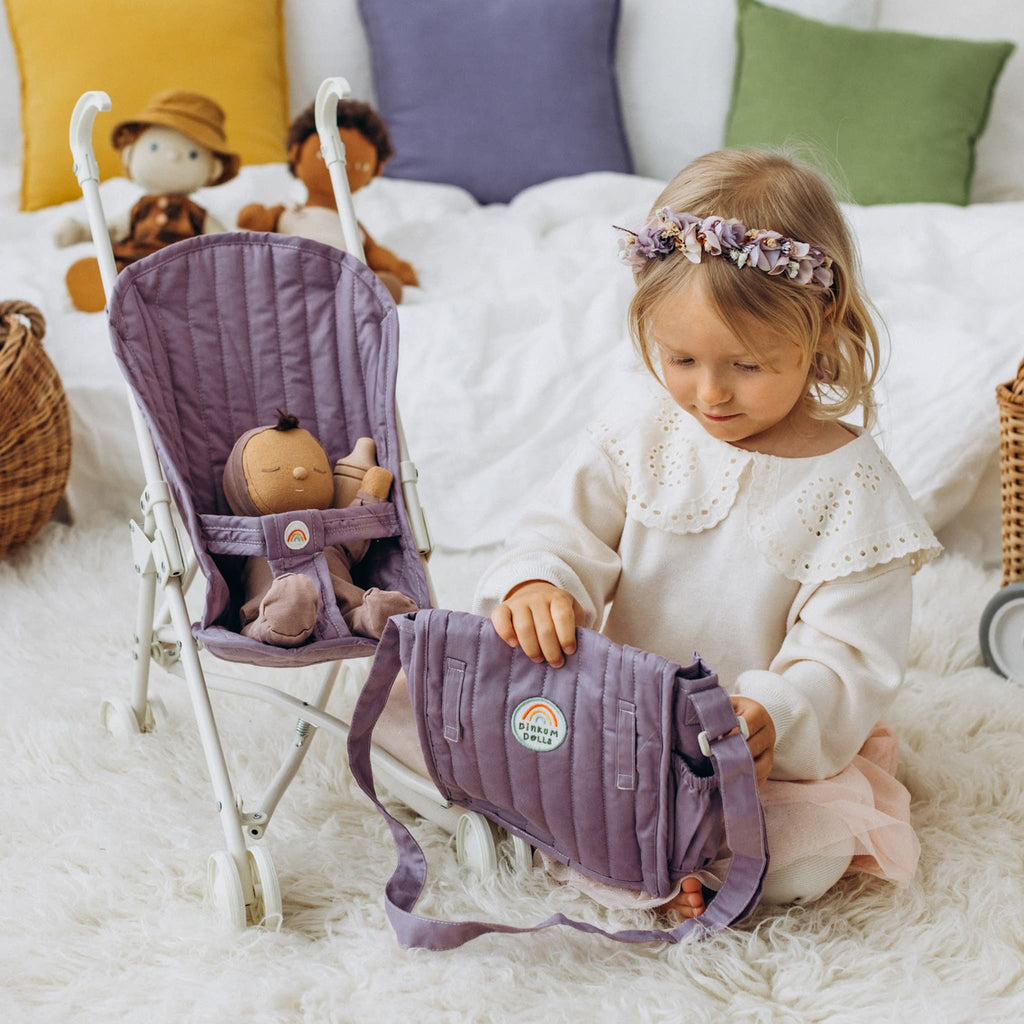 Toddlers playing with lavender stroller indoors – Child sharing stroller with dolls, lavender quilted fabric visible.