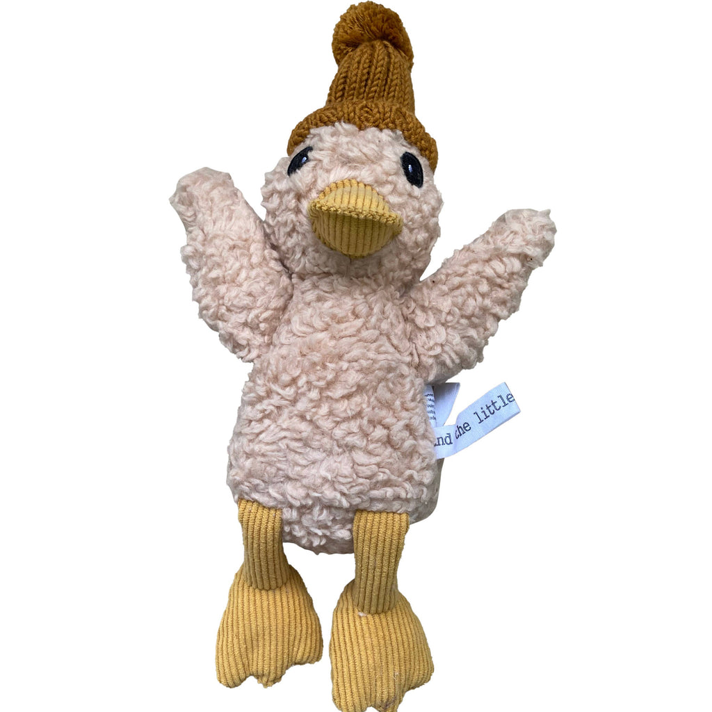 Petunia Duck plush toy made from soft cream cotton plush fabric with caramel corduroy beak and feet, wearing a mustard knitted merino wool beanie with pom-pom, wings outstretched, and a visible “and the little dog laughed” fabric tag.
