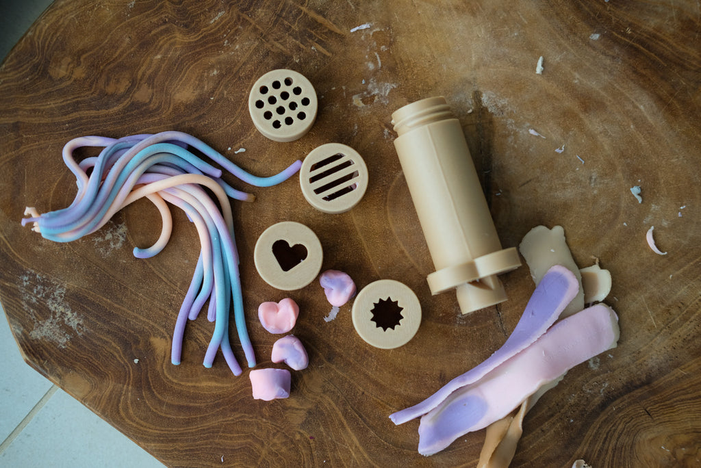 Eco dough extruder kit displayed with rainbow playdough strands and wooden accessories—perfect for sensory and imaginative play.