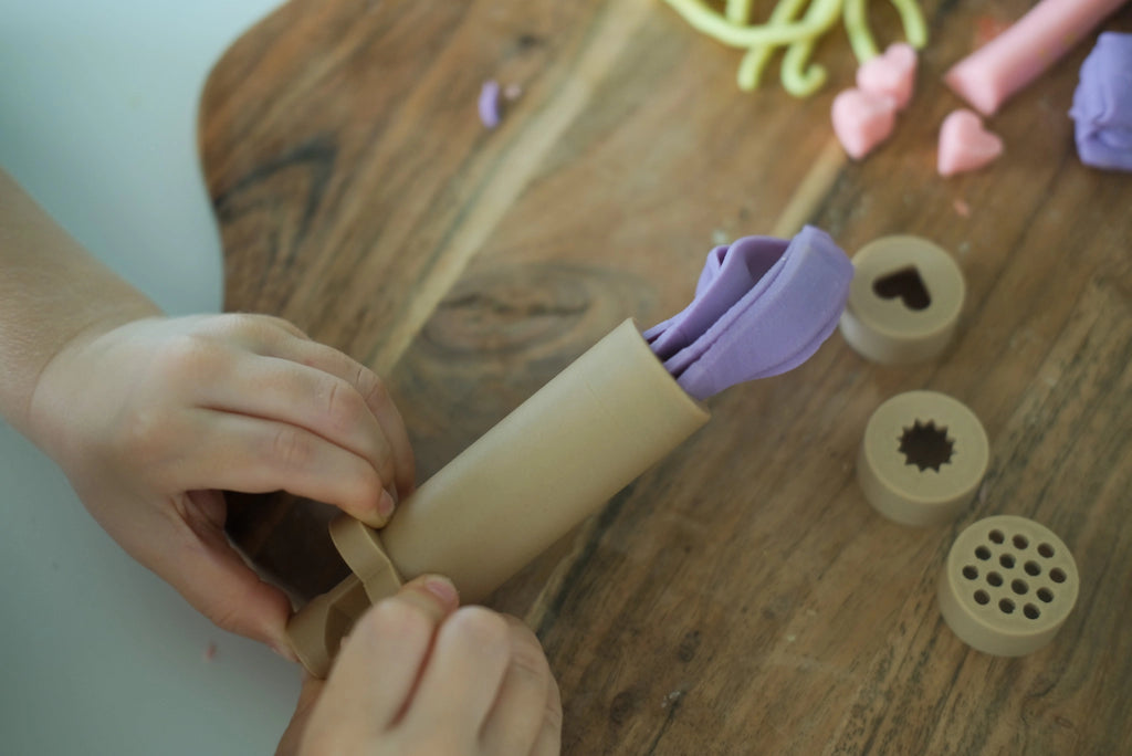 Close-up of natural playdough tools including eco extruder and textured lid designs made from recycled sawdust and PLA.