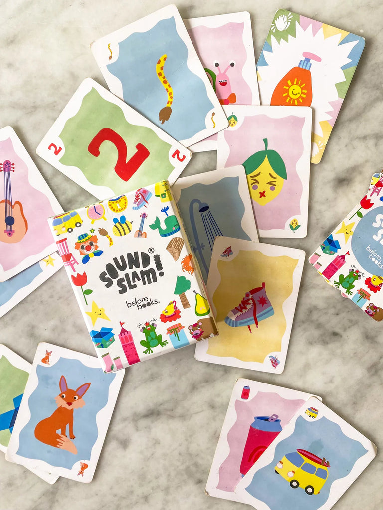 Close-up of several Sound Slam cards laid flat on a table, each featuring a distinct, whimsical illustration without letters, encouraging sound-focused learning.