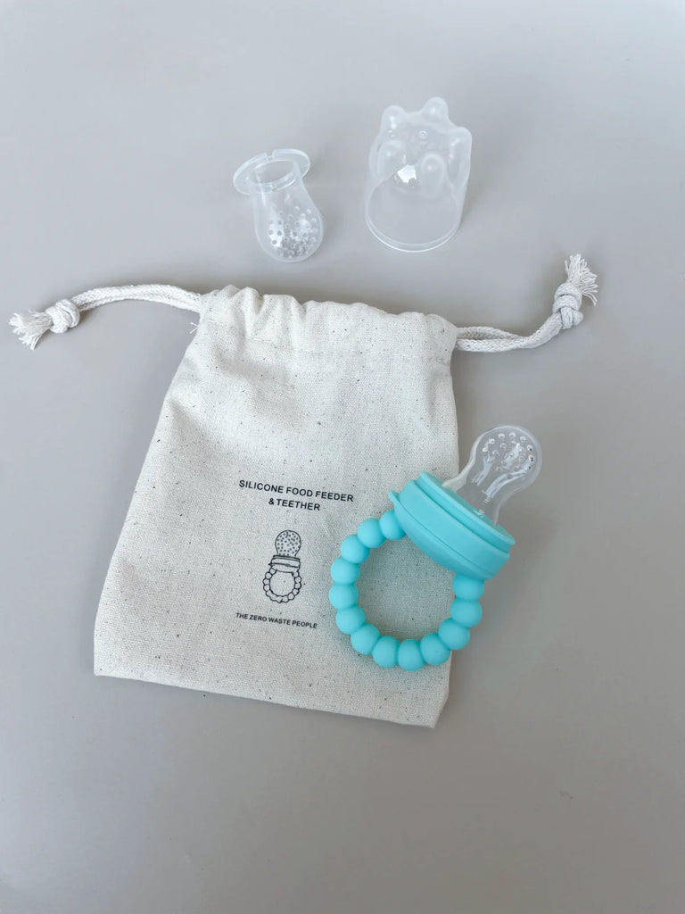 Silicone baby feeder in aqua with two teats and cotton storage bag – BPA-free, dishwasher safe, perfect for teething and safe baby-led feeding.