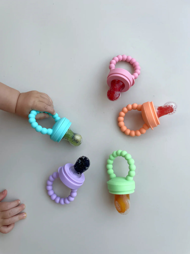 Top-down view of five colourful Zero Waste People silicone baby feeders on a white background – ideal for safe teething and baby-led feeding.
