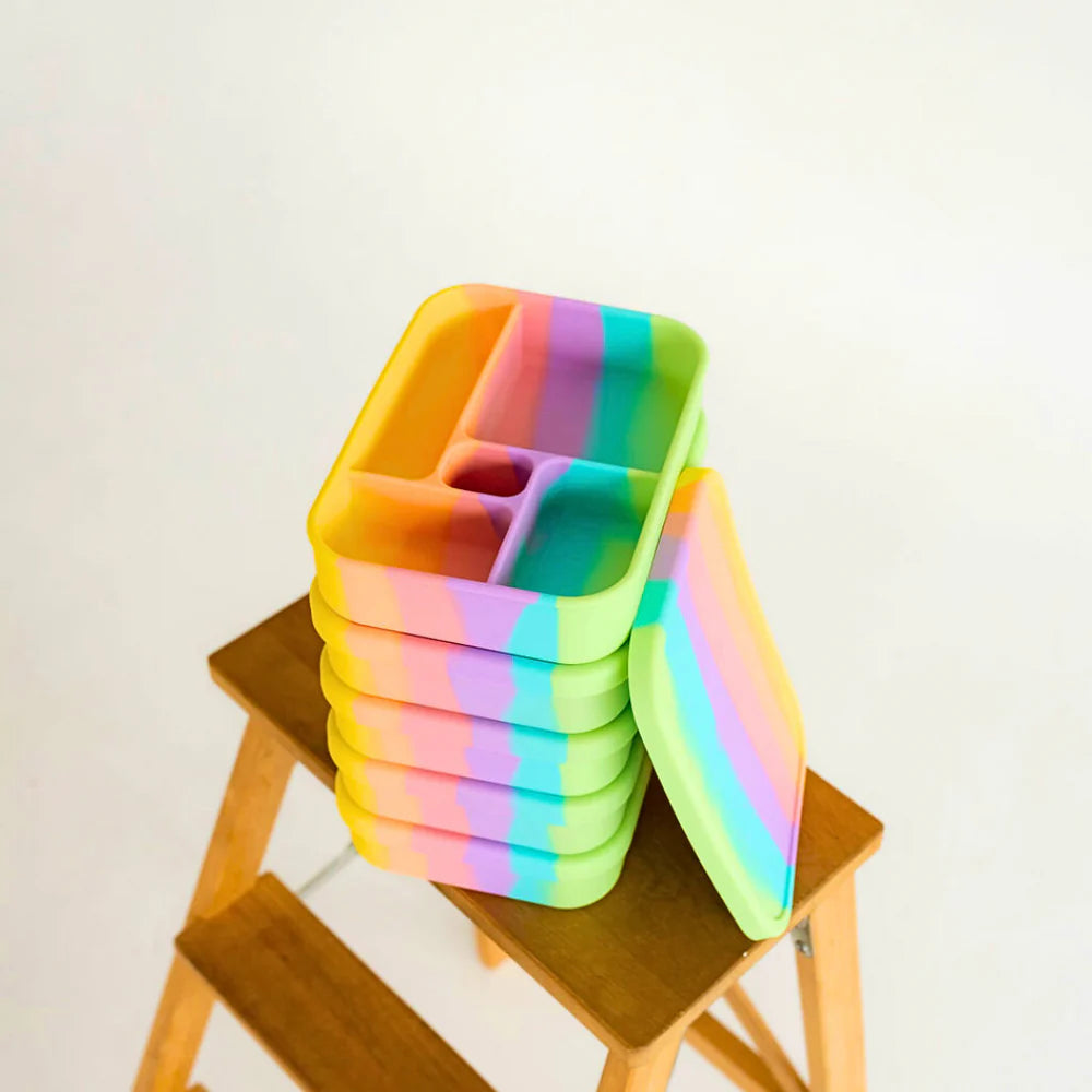 Stack of rainbow Splice Bento Lunchboxes on a wooden stool – durable, microwave-safe and dishwasher-safe lunchbox option.