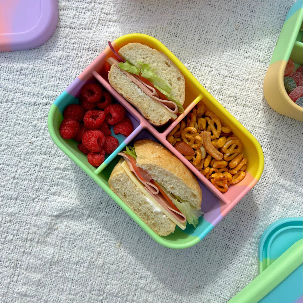 Top view of Zero Waste People Rainbow Midi Box packed with sandwiches, raspberries, and snacks—sustainable and colourful lunch solution.