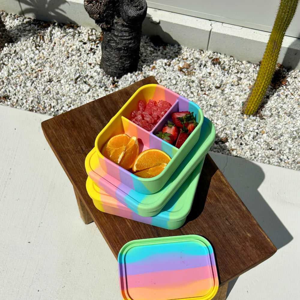 Rainbow Mini Munchbox and Bento Lunchbox stacked on a wooden tray—bright and reusable snack boxes for sustainable lunches.