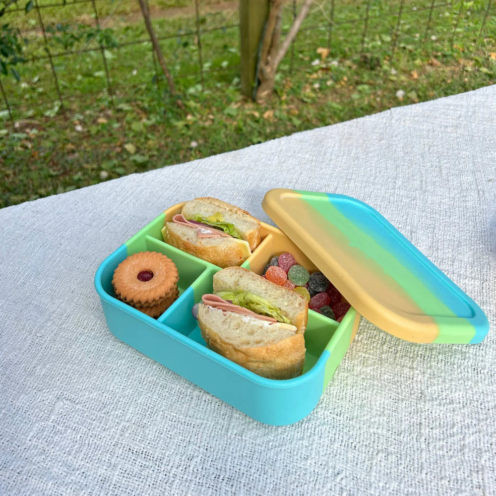 Open Splice Midi Box on picnic cloth with lid placed beside—leak-proof and colourful bento-style lunch container.