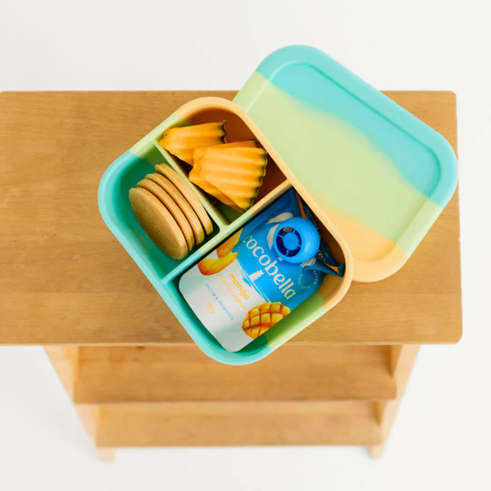 Top view of The Zero Waste People Munchbox Mini on a wooden stool—compact and colourful kids lunchbox for school or daycare.